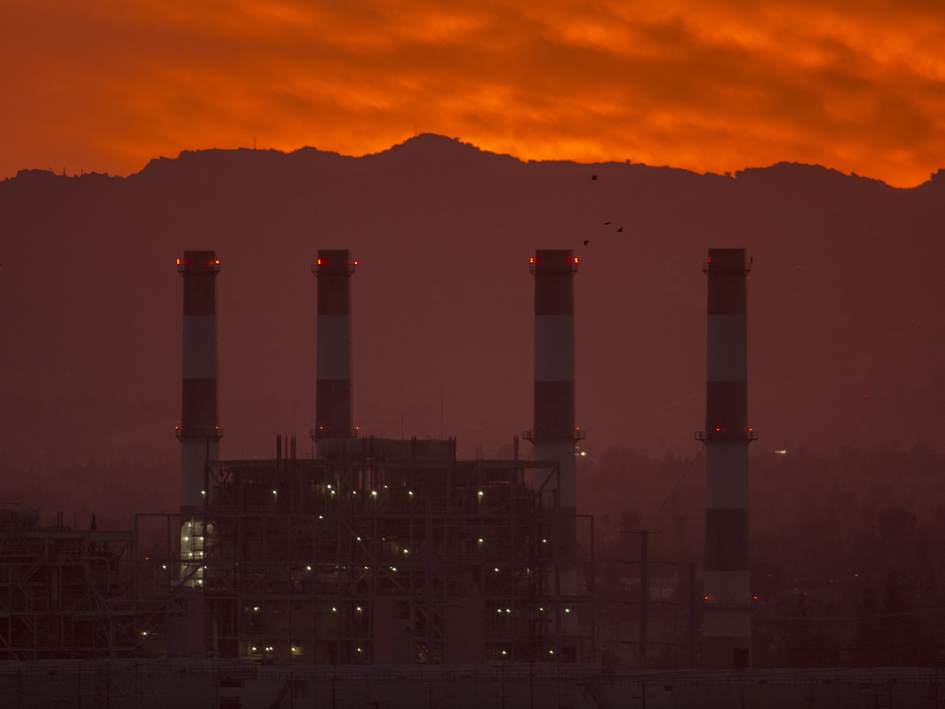 caption: To avoid some of the worst impacts of climate change, greenhouse gas emissions need to be eliminated or offset by midcentury, according to the United Nations. To get there, activist investors say banks and insurance companies need to account for the emissions they contribute to by underwriting and investing in fossil fuel infrastructure like this natural gas plant in California.