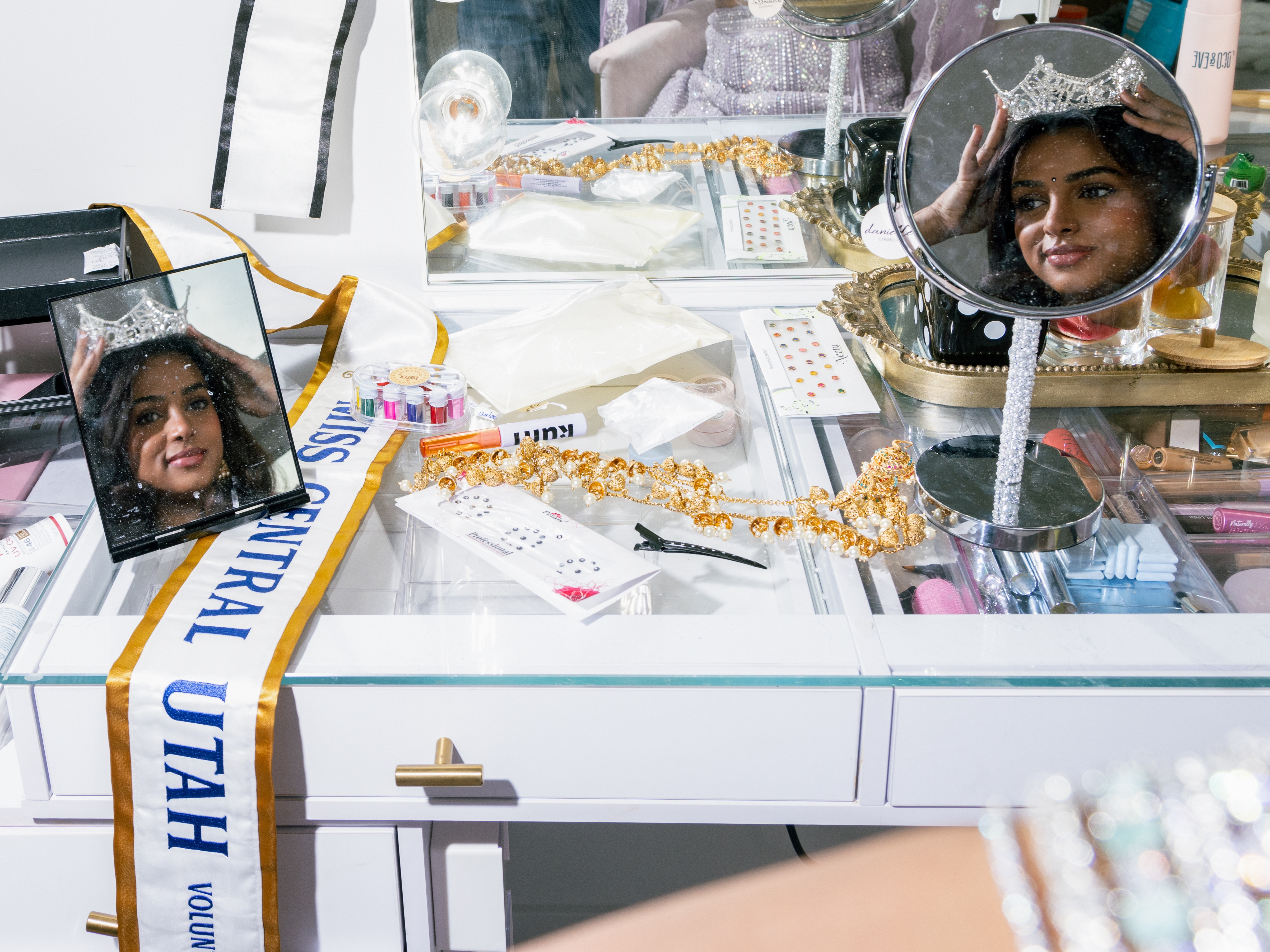 caption: Sahana Kargi tries on the crown she received after competing in the Miss Utah Volunteer pageant in Salt Lake City on Nov. 14, 2024.