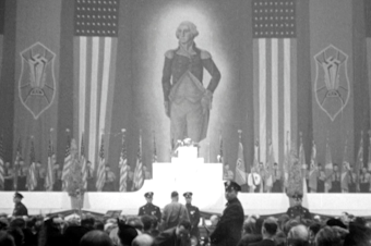caption: An enormous portrait of George Washington hung alongside swastika banners and American flags at Madison Square Garden.