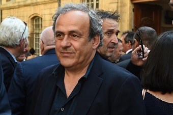 caption: French former soccer great and former UEFA head Michel Platini, seen here in 2018, was detained Tuesday for questioning related to the inquiry into FIFA's awarding of the 2020 World Cup to Qatar.