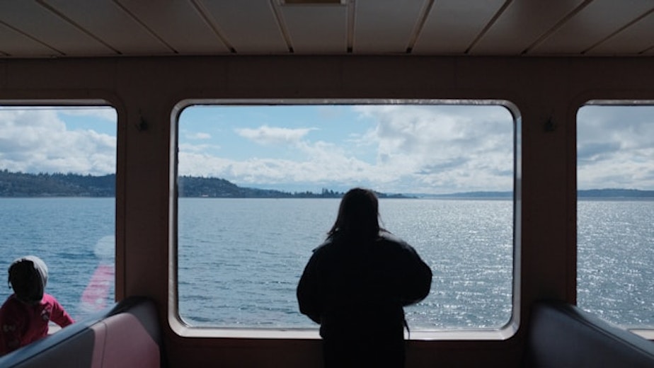 caption: Passengers look over Puget Sound while aboard a Washington State ferry. 