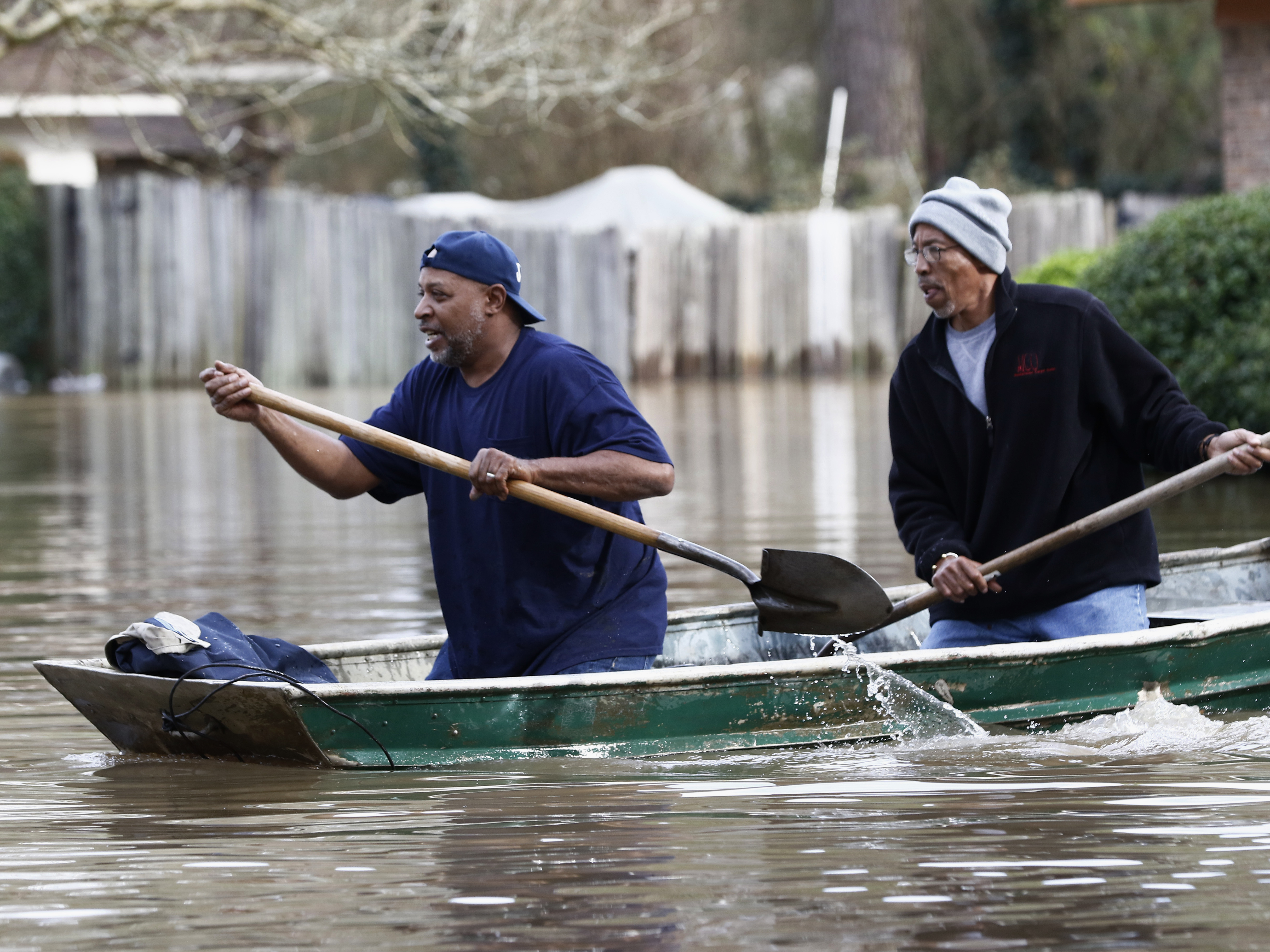 caption: Jackson, Miss., residents use shovels to work their way through Pearl River floodwater on Sunday.