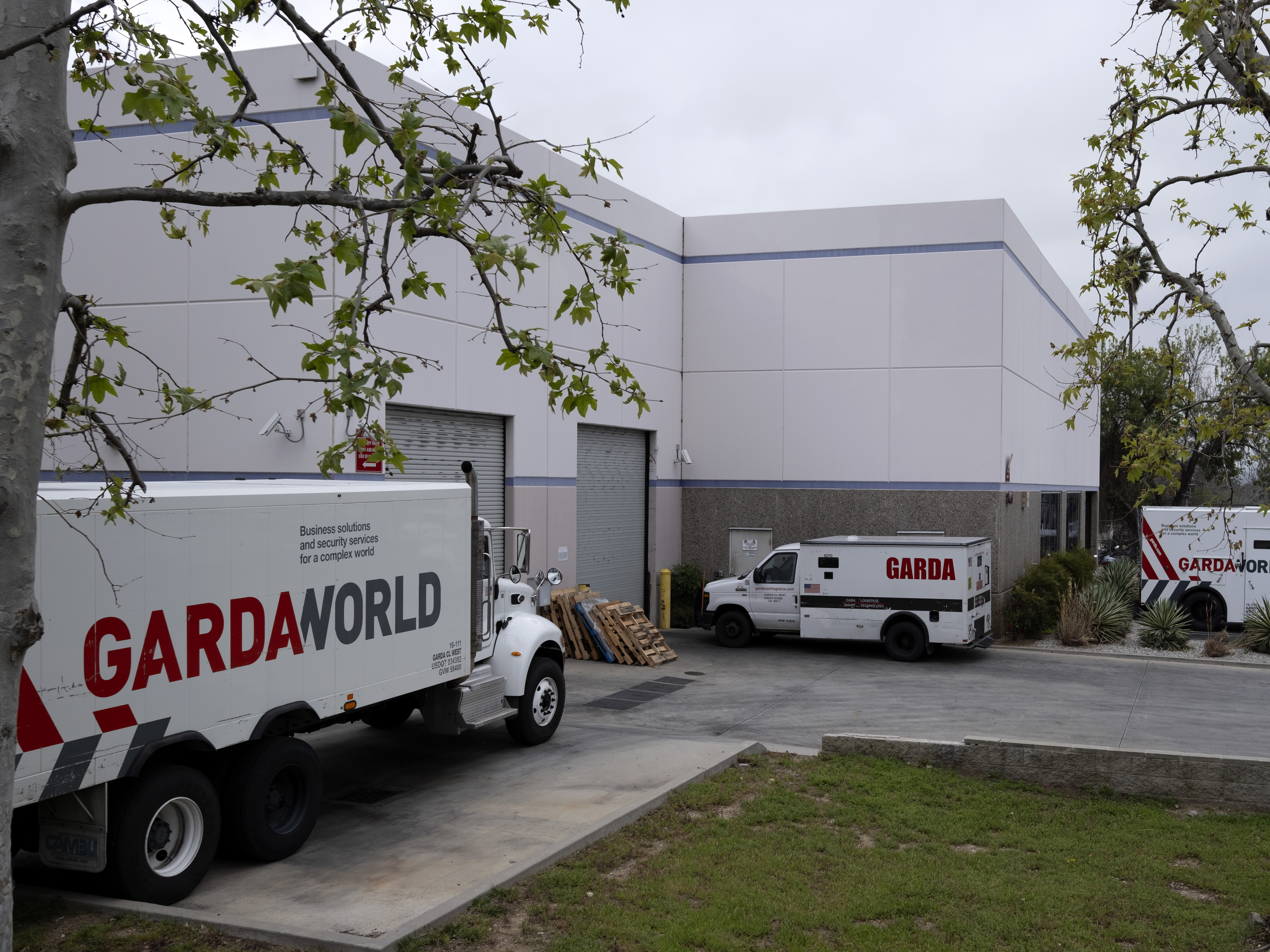 caption: Armored trucks are parked outside the GardaWorld facility in the Sylmar section of Los Angeles on Thursday, April 4, 2024.