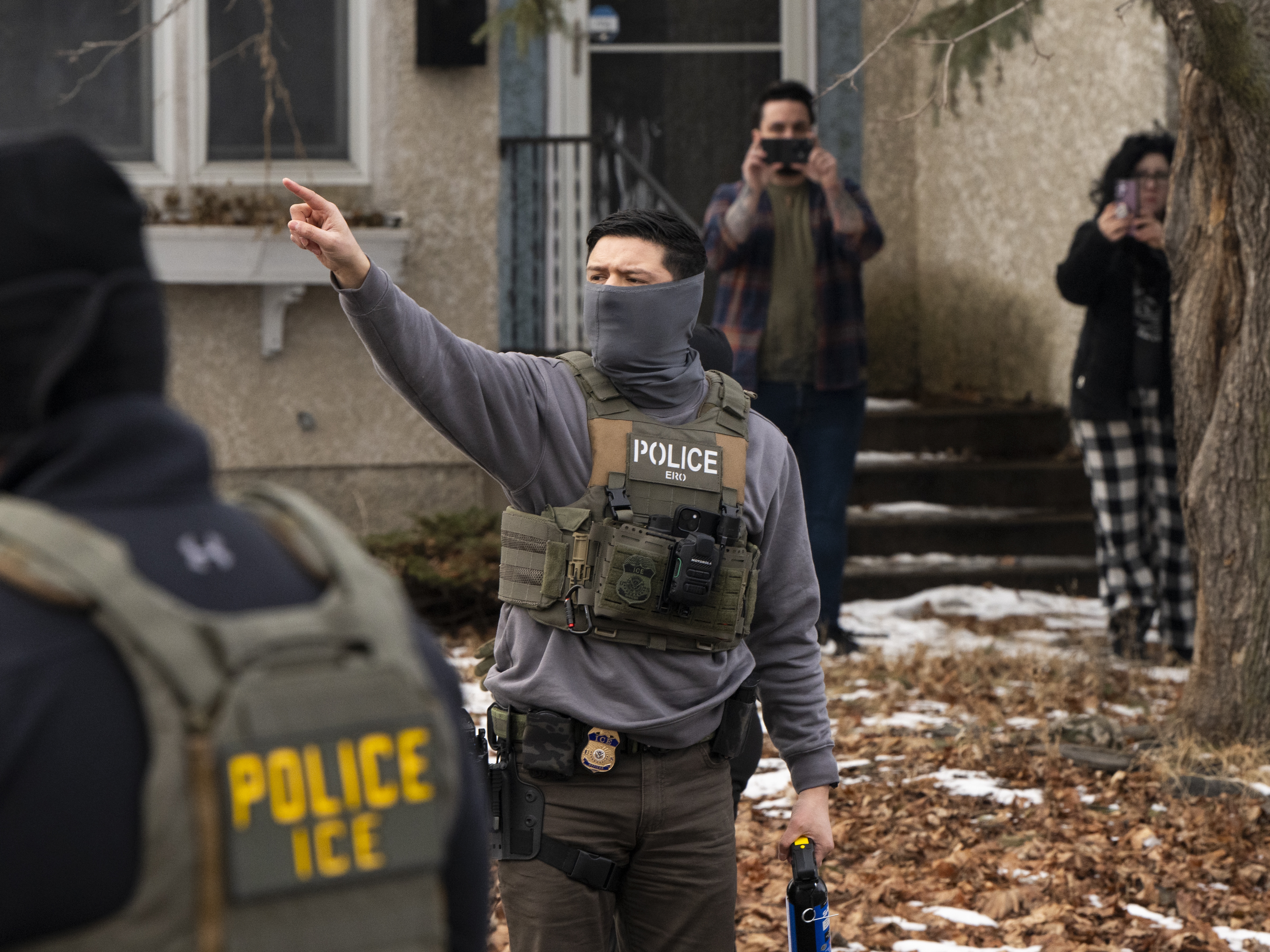 caption: Observers film Immigration and Customs Enforcement agents as they hold a perimeter after one of their vehicles got a flat tire on Penn Avenue in Minneapolis on Feb. 5.