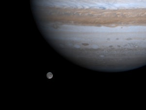 caption: The solar system's largest moon, Ganymede, is pictured with Jupiter in a photo by NASA's Cassini spacecraft, Dec. 3, 2000. NASA's Juno mission will get close to Ganymede on Monday.