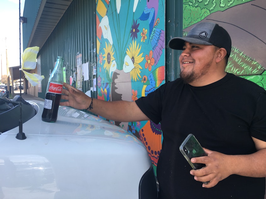 caption: An H2A farmworker takes a moment to enjoy a coke outside of El Estudillo Food Store. H2A foreign farmworkers are allowed to drive into town for a couple of hours to get supplies -- usually on Wednesdays and Fridays. 
