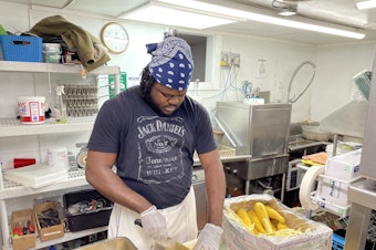 caption: Jason Brissett, a kitchen worker who came to the U.S. last month from Jamaica through an H-2B visa, is bracing for 80-hour work weeks this summer, to help make up for staffing shortages.