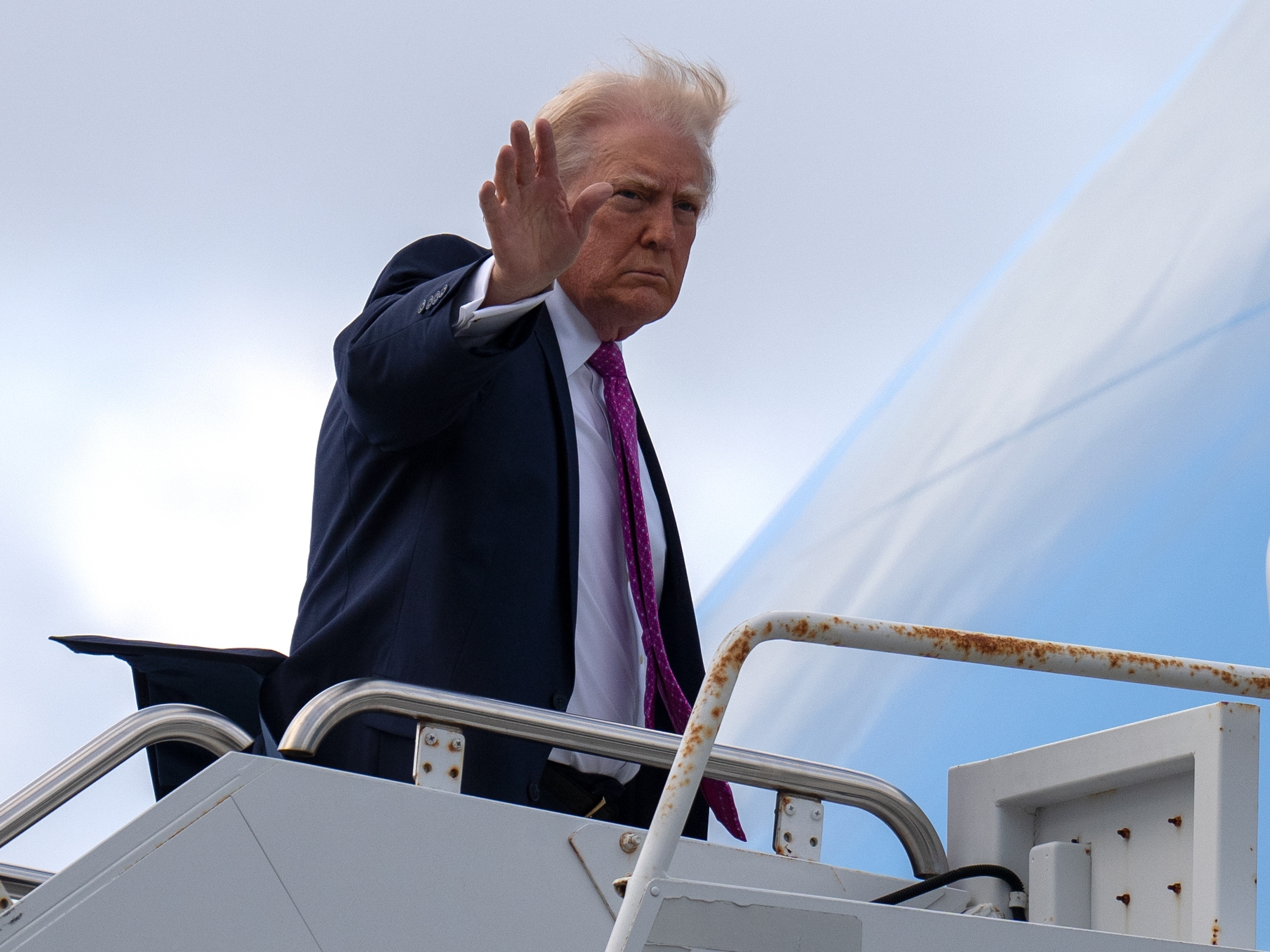 caption: President Donald Trump waves as he boards Air Force One, Sunday, March 29, 2026, at Palm Beach International Airport in West Palm Beach, Fla.