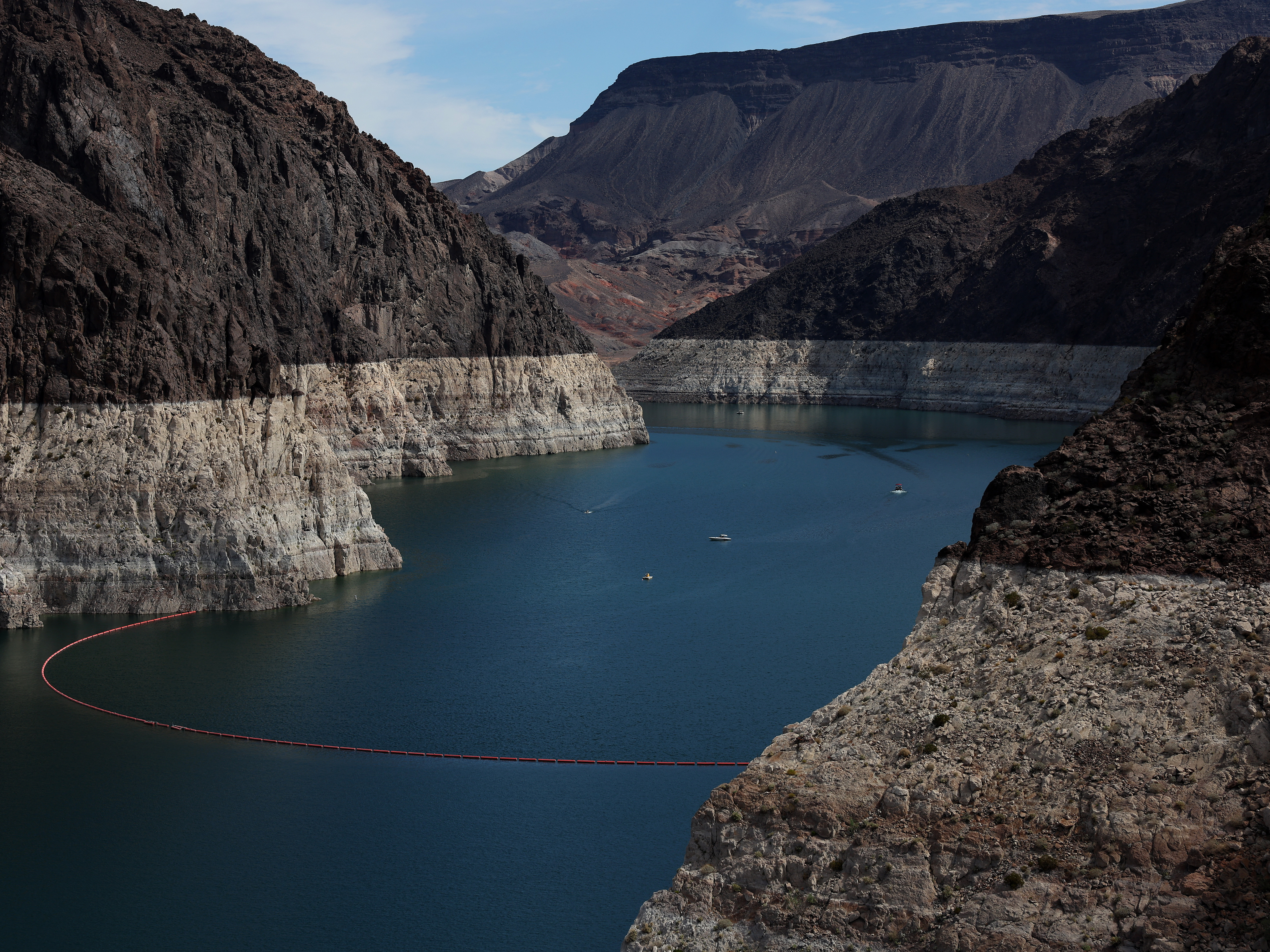 caption: A bleached "bathtub ring" is visible on the banks of Lake Mead on Aug. 19, 2022. The lake's water levels continue to fall, leading to a grim pattern for local authorities: the discovery of human remains.