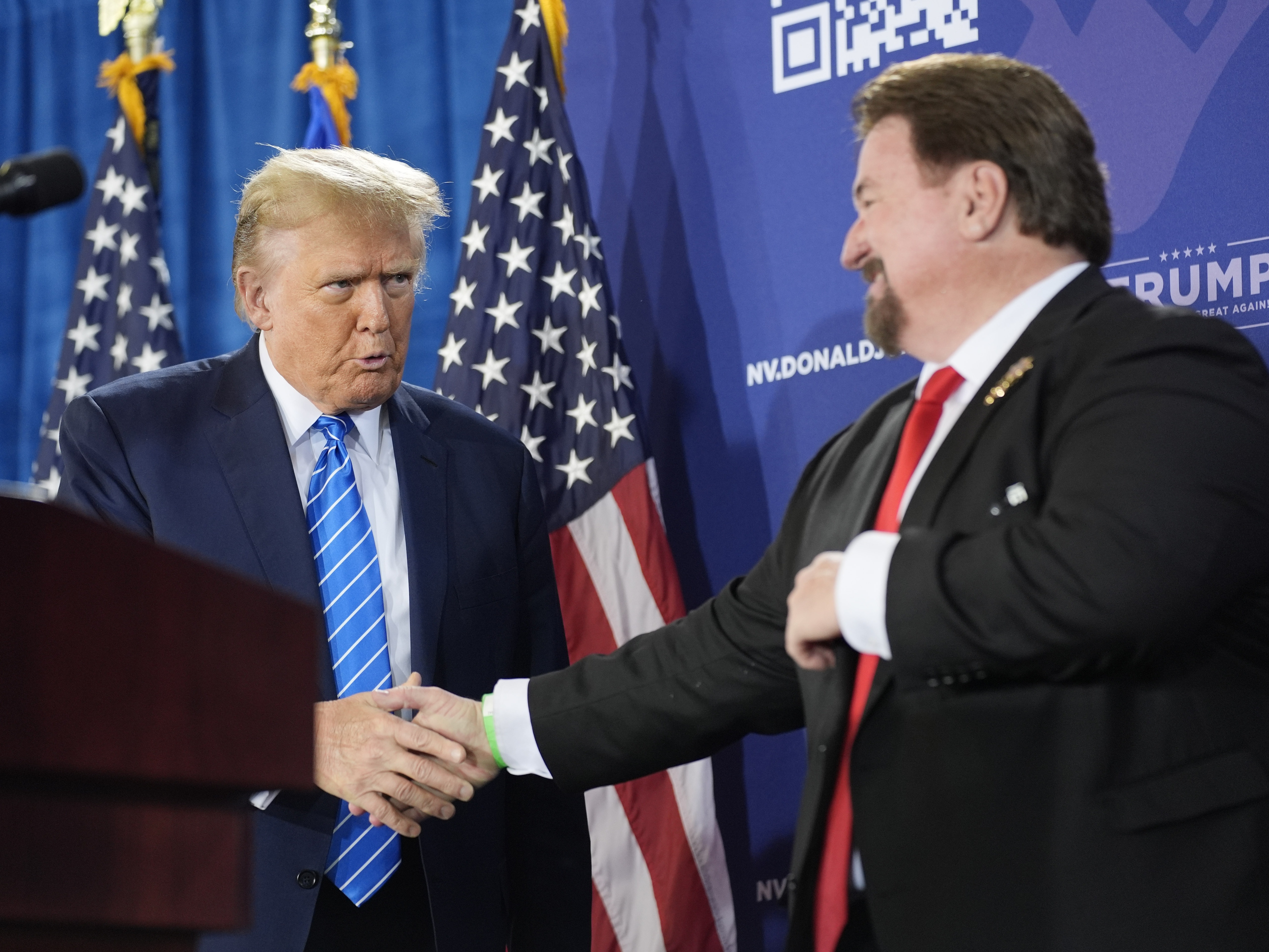 caption: Michael McDonald, the chair of Nevada’s Republican Party, shakes hands with former President Donald Trump at a January event for Trump’s reelection campaign in Las Vegas. McDonald is one of this year’s 14 presidential electors who are linked to efforts to reverse Trump’s 2020 defeat.
