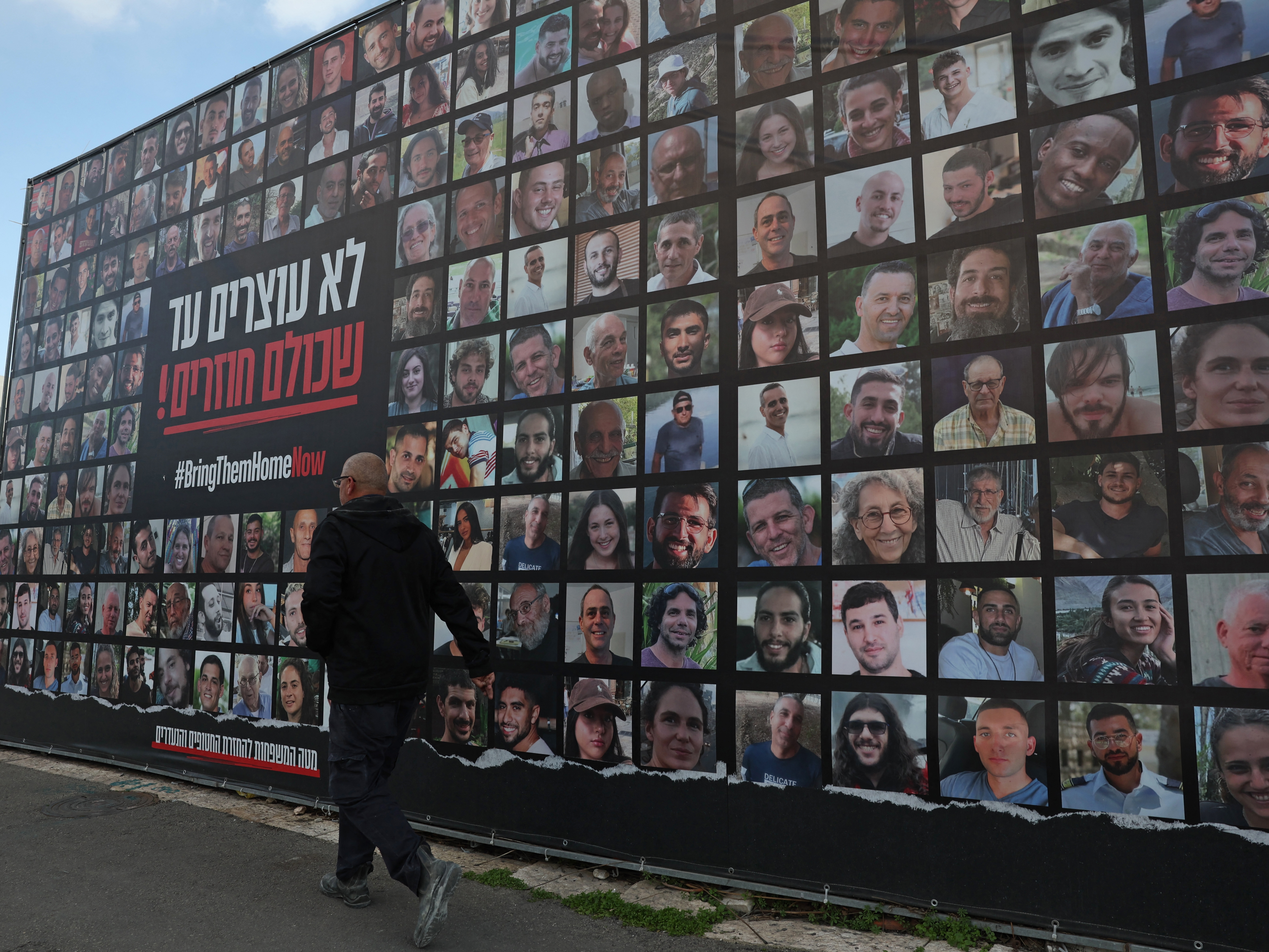 caption: A man walks past a billboard bearing the portraits of Israeli hostages held in the Gaza Strip since the Oct. 7, 2023, attacks by Hamas-led militants, in Jerusalem on Monday, as the country marked the 500th day since their abduction.
