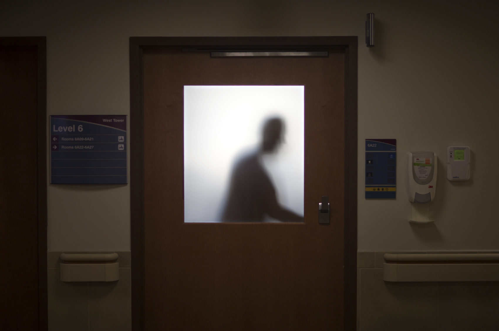 caption: In this Jan. 24, 2014 photo, a doctor is silhouetted against a glass window while leaving an exam room after visiting a patient at Grady Memorial Hospital, in Atlanta. (David Goldman/AP)