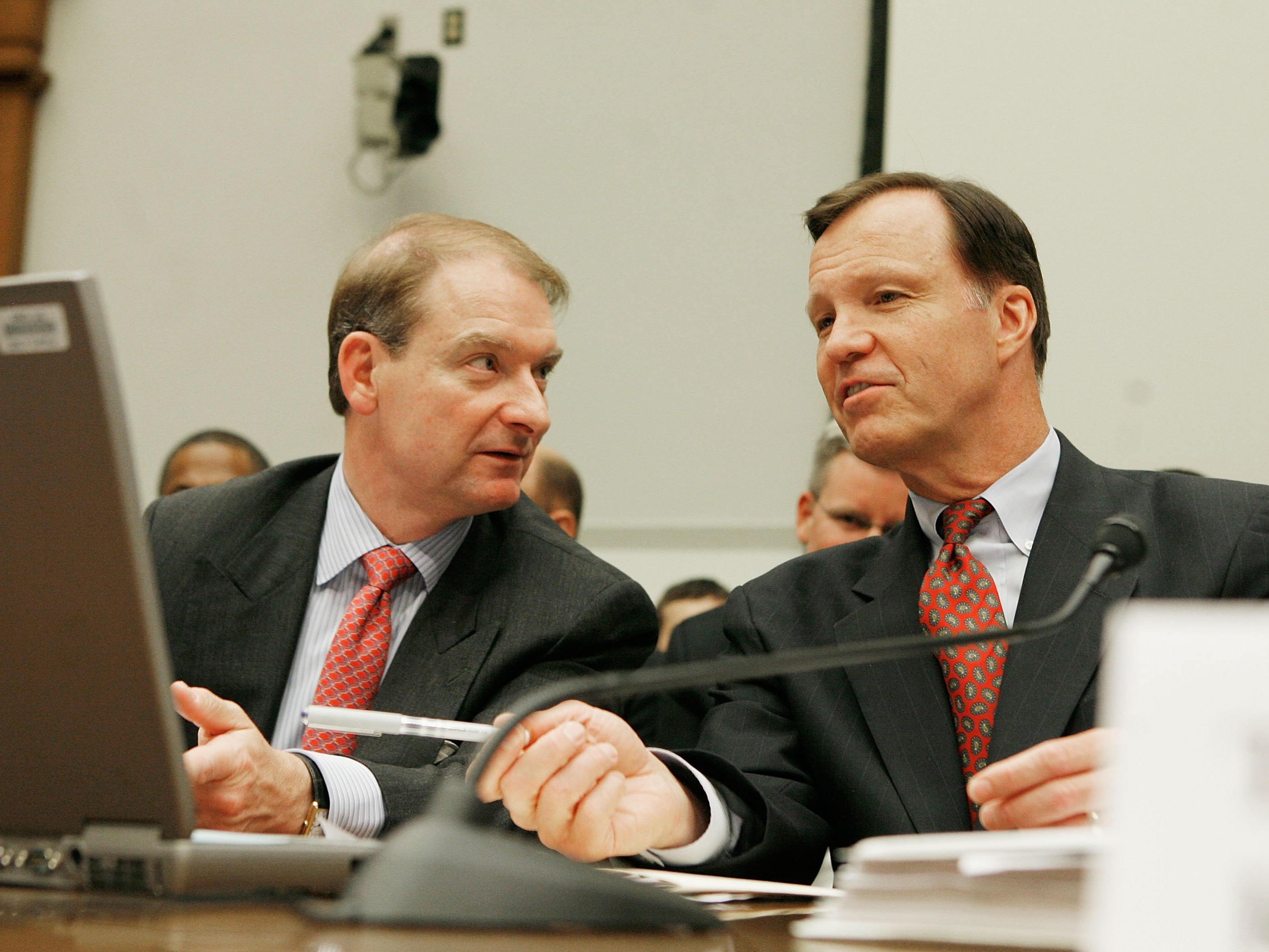 caption: Paul Atkins, left, talks to then SEC Chair Christopher Cox during a House Financial Services Committee hearing on Capitol Hill in Washington, D.C., on June 26, 2007. Atkins was then an SEC commissioner, and he has now been picked by President-elect Trump as the next head of the agency,