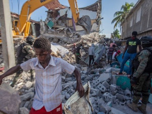 caption: Haitians in Les Cayes assess the damage Sunday after a magnitude 7.2 earthquake struck a day earlier.