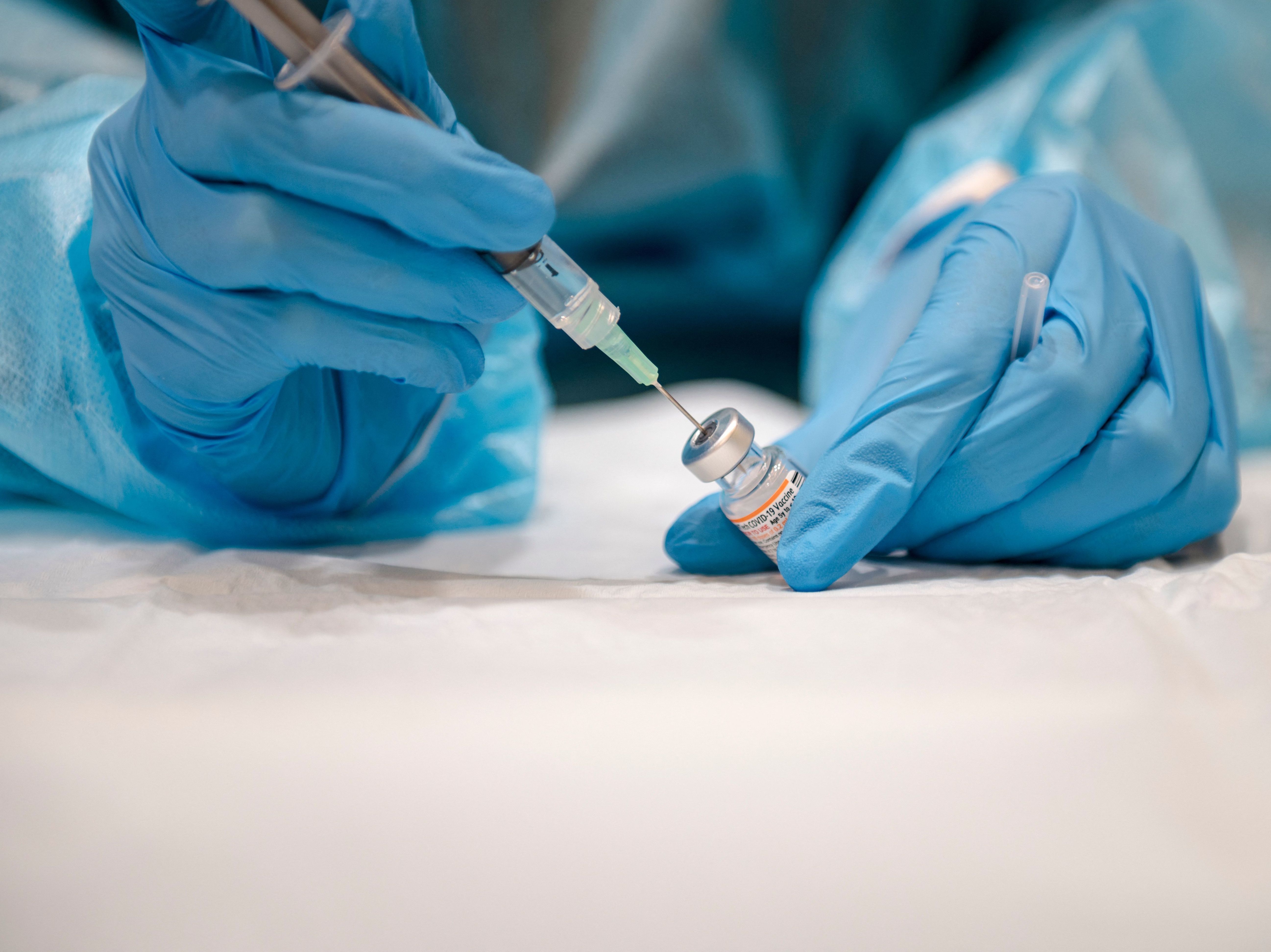 caption: A nurse prepares the Pfizer-BioNTech Covid-19 vaccine for children for distribution in Montreal late last year.