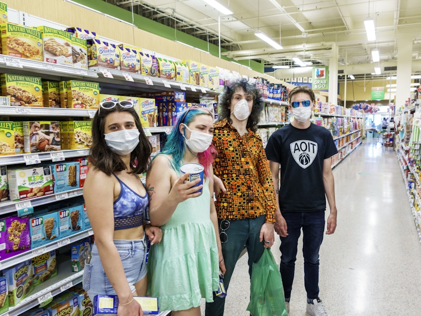 caption: Increasingly, many people in the U.S., like these teens in a Miami grocery story in August, now routinely wear face masks in public to help stop COVID-19's spread. But social distancing and other public health measures have been slower to catch on, especially among young adults, a national survey finds.