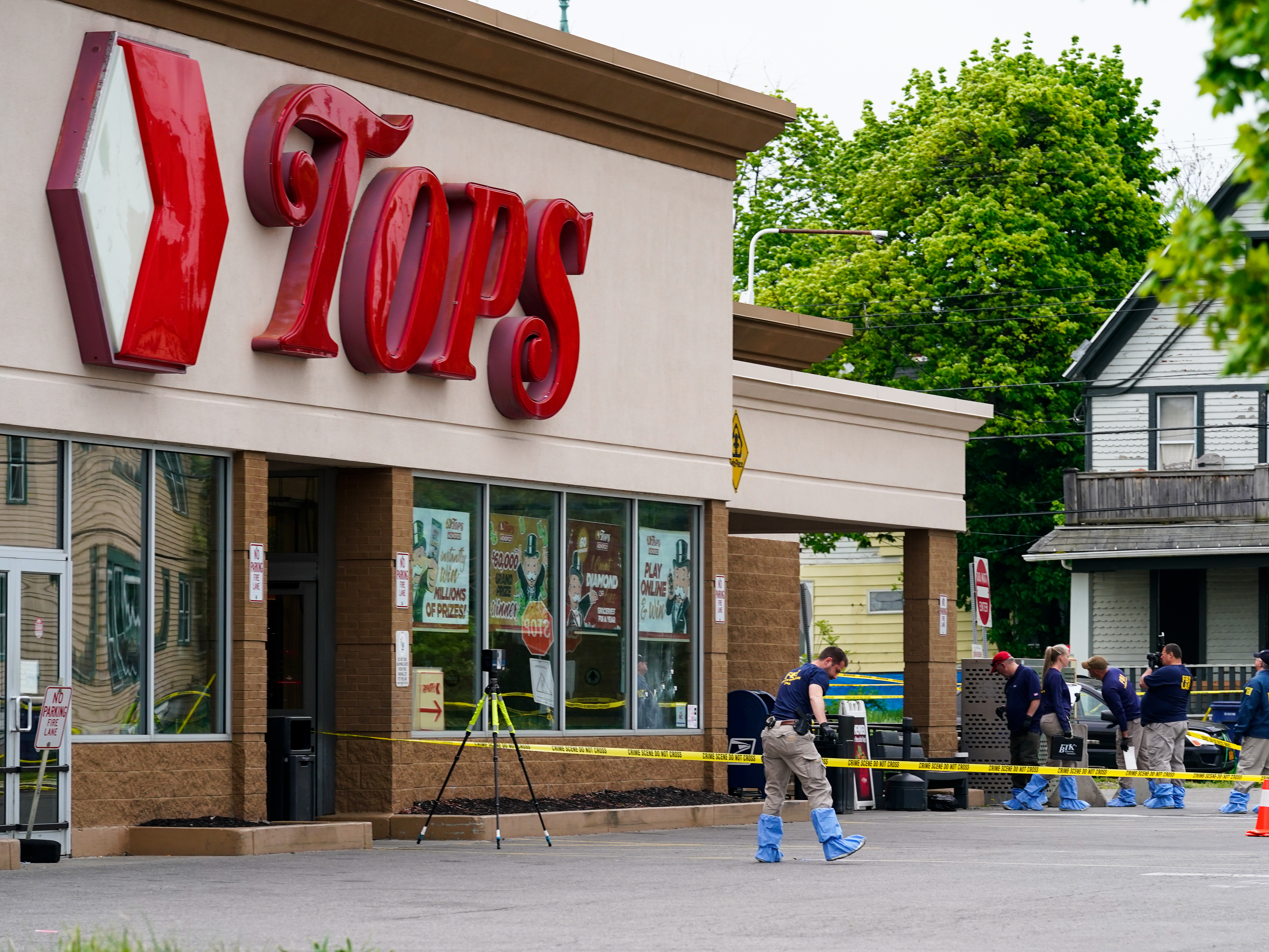 caption: Investigators work the scene last month after the mass shooting at a supermarket in Buffalo, N.Y.
