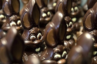 caption: Chocolate Easter bunnies wait to be decorated at a shop in Belgium.