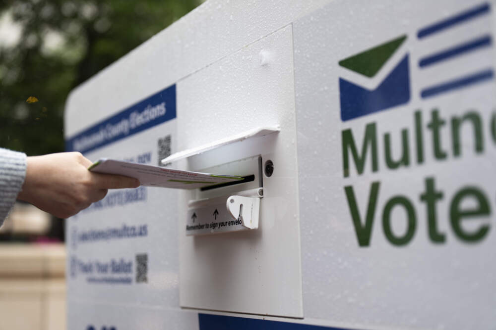 caption: FILE - A person drops off a vote-by-mail ballot at a dropbox in Pioneer Square during primary voting on May 21, 2024, in Portland, Ore. (Jenny Kane/AP)