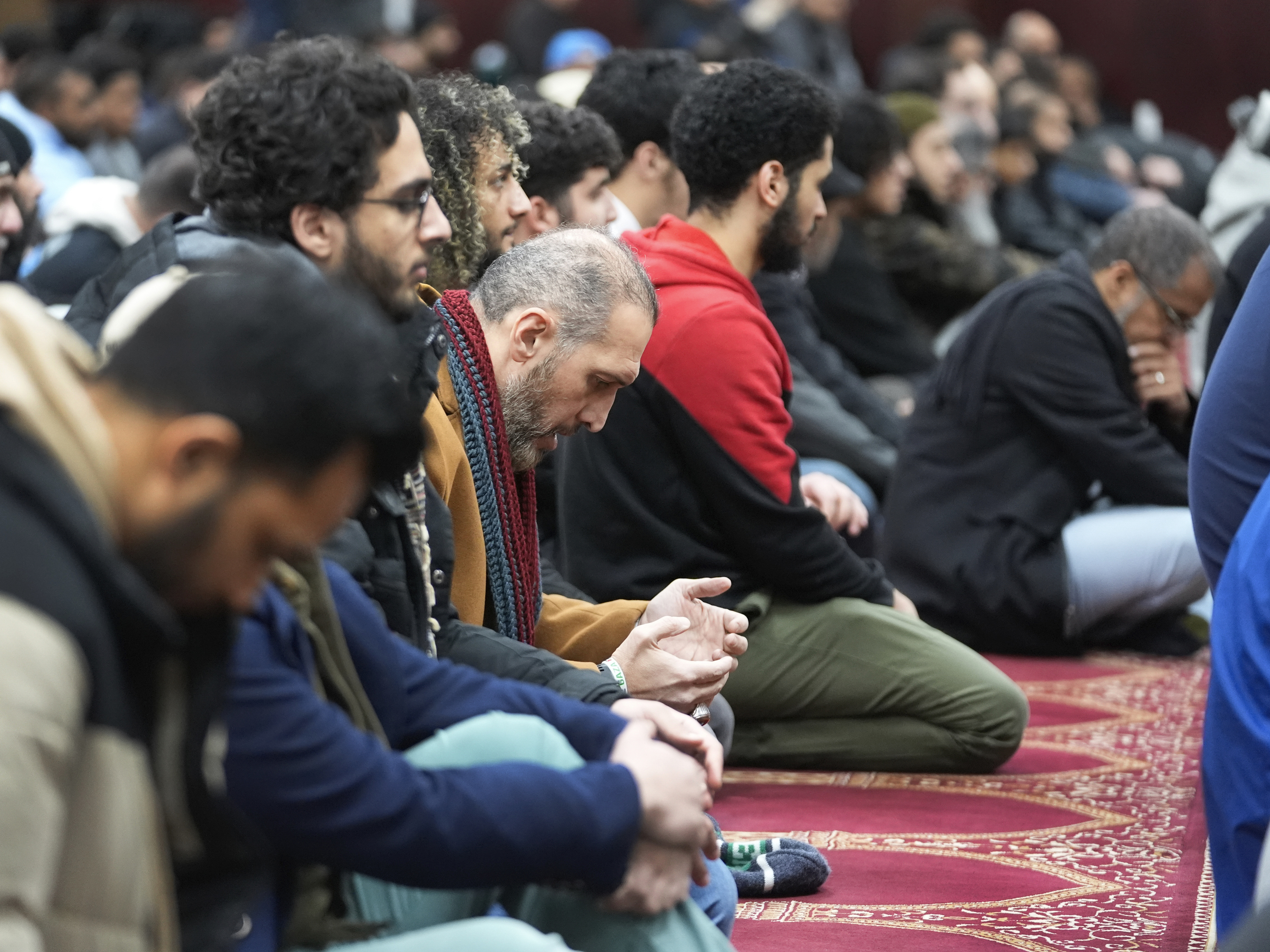 caption: Muslim men listen to Imam Omar Suleiman speak at the Islamic Center of Detroit in Detroit.