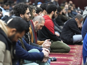 caption: Muslim men listen to Imam Omar Suleiman speak at the Islamic Center of Detroit in Detroit.