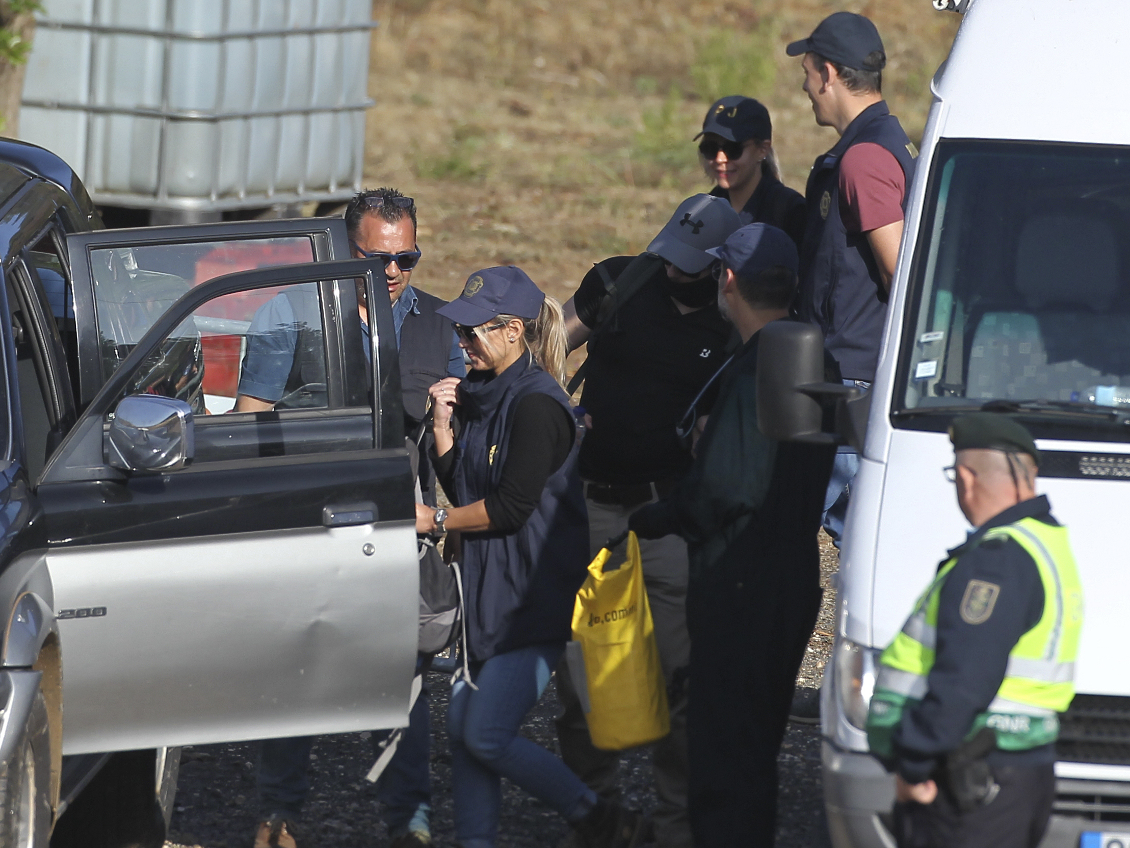 caption: Police search teams prepare to set out from an operation tent near Barragem do Arade, Portugal, Wednesday May 24, 2023.