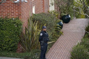 caption: A police officer stands outside the home of House Speaker Nancy Pelosi and her husband Paul Pelosi in San Francisco on Friday, after Paul was attacked and severely beaten by an assailant who broke into their home early Friday.