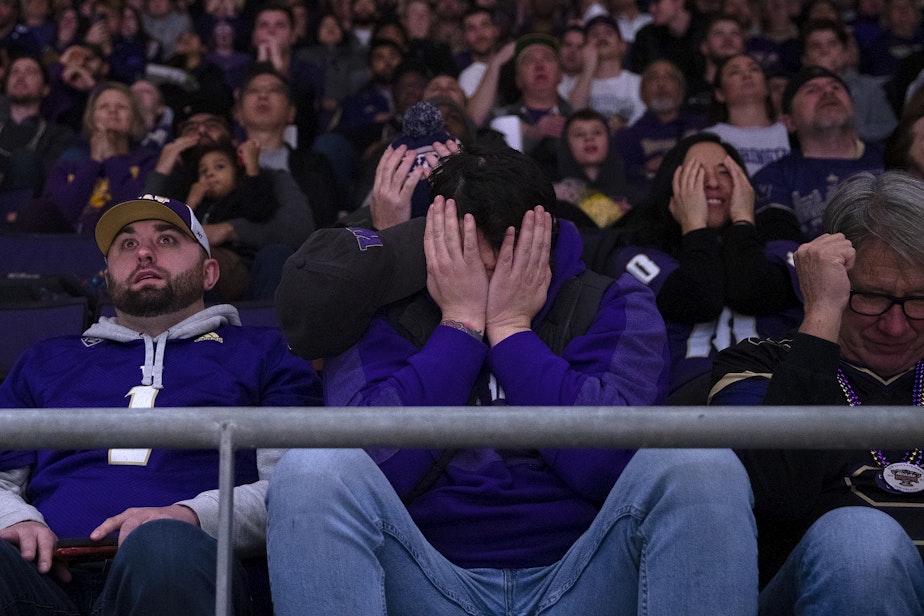 caption: University of Washington fans react to a play in the first quarter of the college playoff National Championship game against Michigan on Monday, January 8, 2024, at Alaska Airlines Arena in Seattle. 