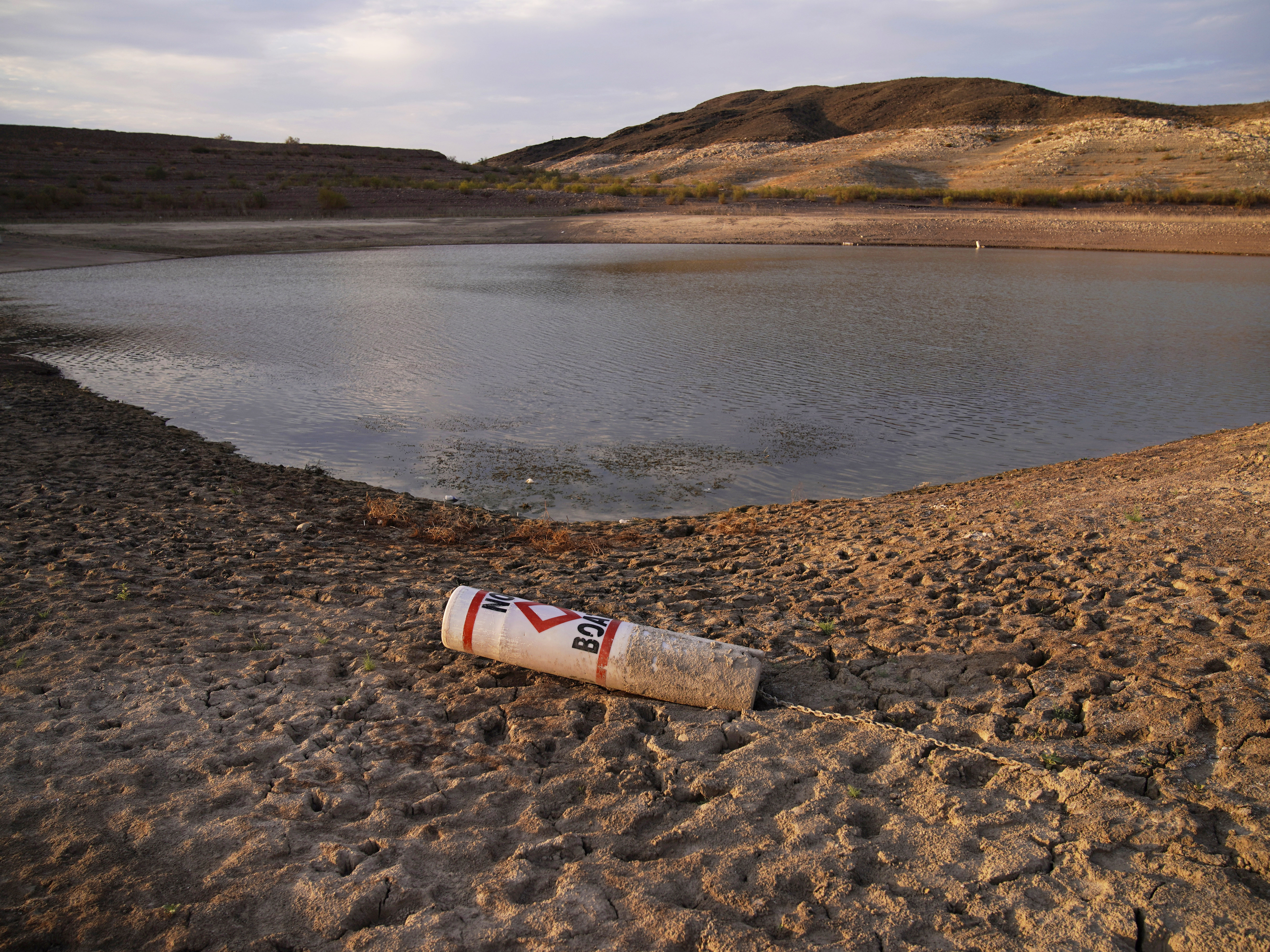 caption: A buoy rests on the ground at a closed boat ramp on Lake Mead near Boulder City, Nev., on Aug. 13, 2021.