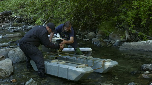 caption: <p>Miners Sean Wheeler (left) and Ron Larson secure the motor to Larson&rsquo;s hydraulic dredge. Dredges allow miners to process up to forty times more sediment than a traditional gold pan.</p>
