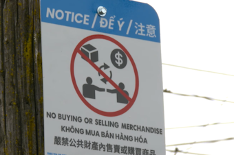 caption: A sign posted by Seattle police in the Chinatown-International District to counter illegal street vending in the area. 
