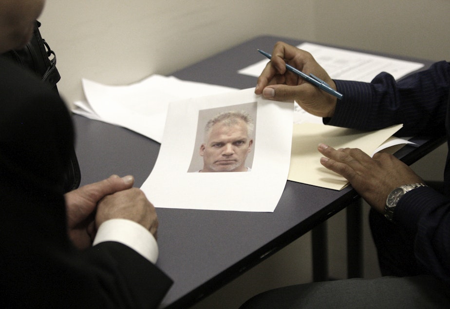 caption: A Dallas police officer shows a robbery victim a photo of a suspect in 2009. The Dallas police department in Dallas has been a leader in blind lineups, which experts say reduces mistakes made by eye witnesses. 