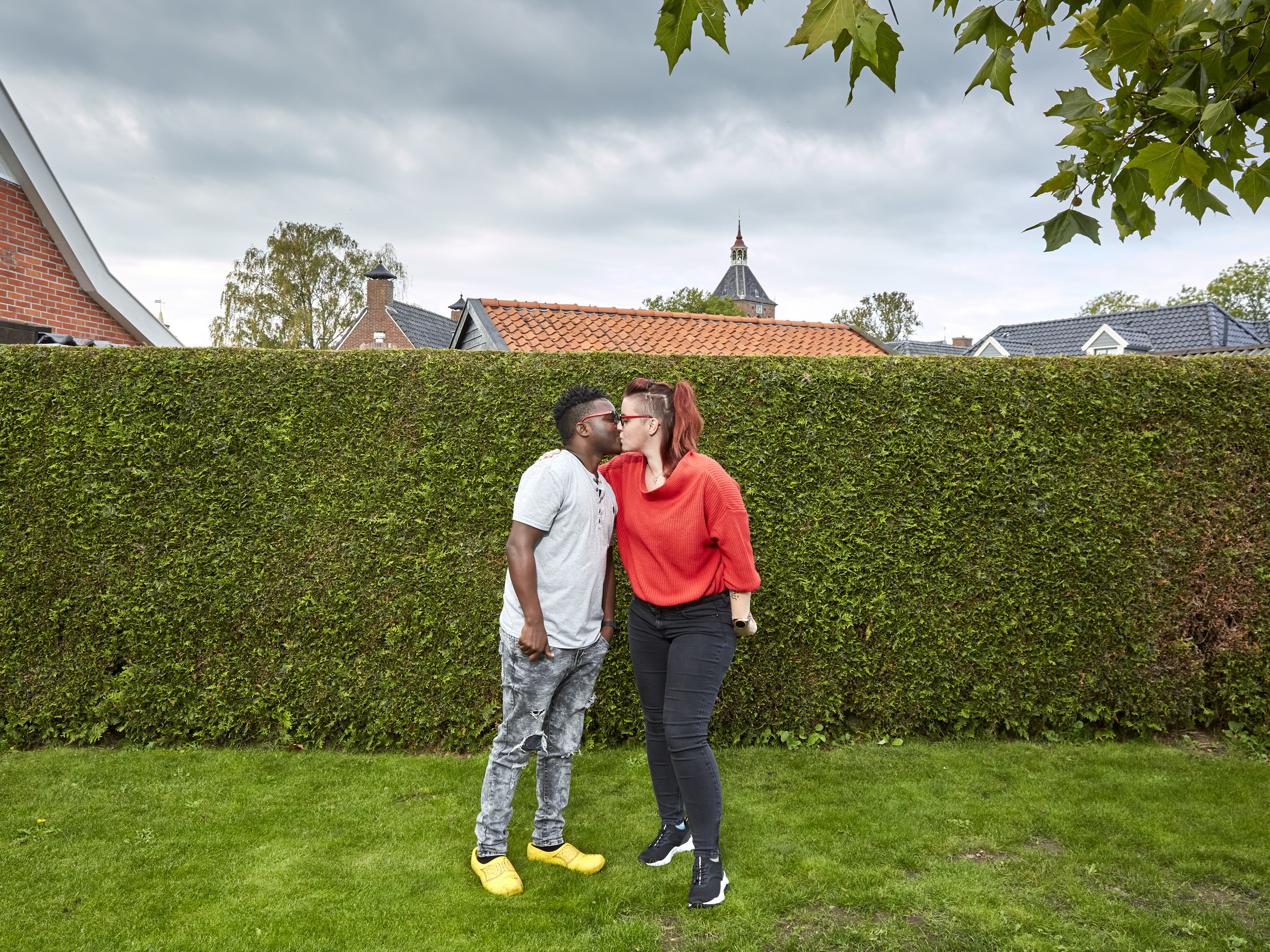 caption: Patrick Phiri of Malawi and fiance Fiona ten Have of Holland kiss in her parents' garden. The couple met in Malawi, where they worked for the same charity, and fell in love. A 3-week visit to the Netherlands turned into 7 months due to pandemic lockdowns and travel restrictions.