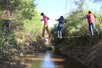 caption: U.S. citizens use ropes to cross the Rio Grande from San Antonio del Bravo, Mexico, into Candelaria, Texas. U.S. citizens depend on the free health clinic in San Antonio del Bravo.