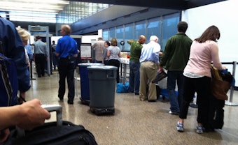 caption: Passengers go through security checkpoints at Sea-Tac International Airport.