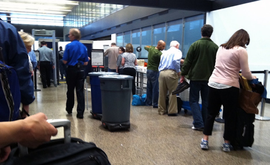 caption: Passengers go through security checkpoints at Sea-Tac International Airport.