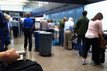 caption: Passengers go through security checkpoints at Sea-Tac International Airport.