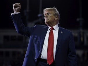 caption: Former President Donald Trump pumps his fist as he leaves the stage at the conclusion of a campaign rally at the SNHU Arena on Saturday in Manchester, N.H.