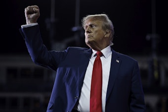 caption: Former President Donald Trump pumps his fist as he leaves the stage at the conclusion of a campaign rally at the SNHU Arena on Saturday in Manchester, N.H.