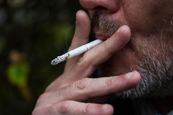 caption: This picture taken on Oct. 31, 2023, shows a man smoking a cigarette in Sundbyberg, near Stockholm, Sweden. The WHO has issued a new report on global tobacco use, finding rates are going down.