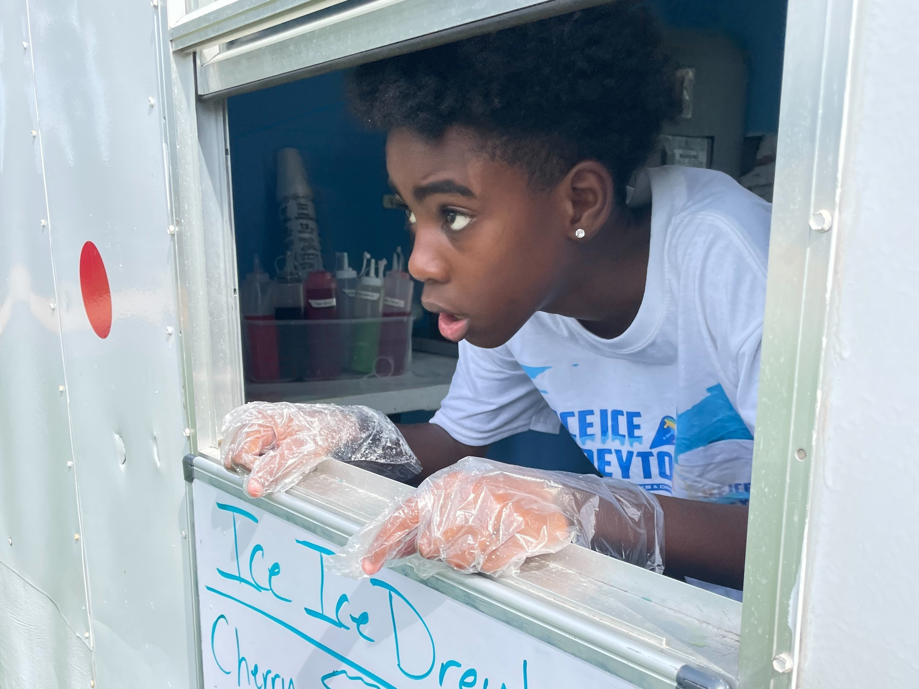 caption: Dreyton McDonald sells snow cones from his mobile shop, Ice Ice Dreyton, in Ocala, Fla.