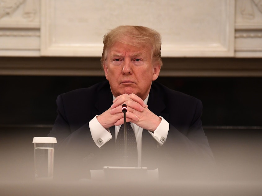 caption: President Trump looks on during a meeting with restaurant executives in the State Dining room of the White House Monday.