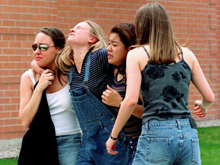 caption: In this April 20, 1999, file photo, women head to a library near Columbine High School where students and faculty members were evacuated after two gunmen went on a shooting rampage in the school in the Denver suburb of Littleton, Colo.