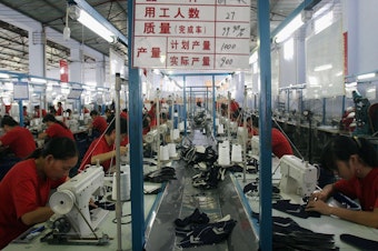 Workers make parts of sports shoes at a factory in Chengdu, China, on Aug. 13, 2005.