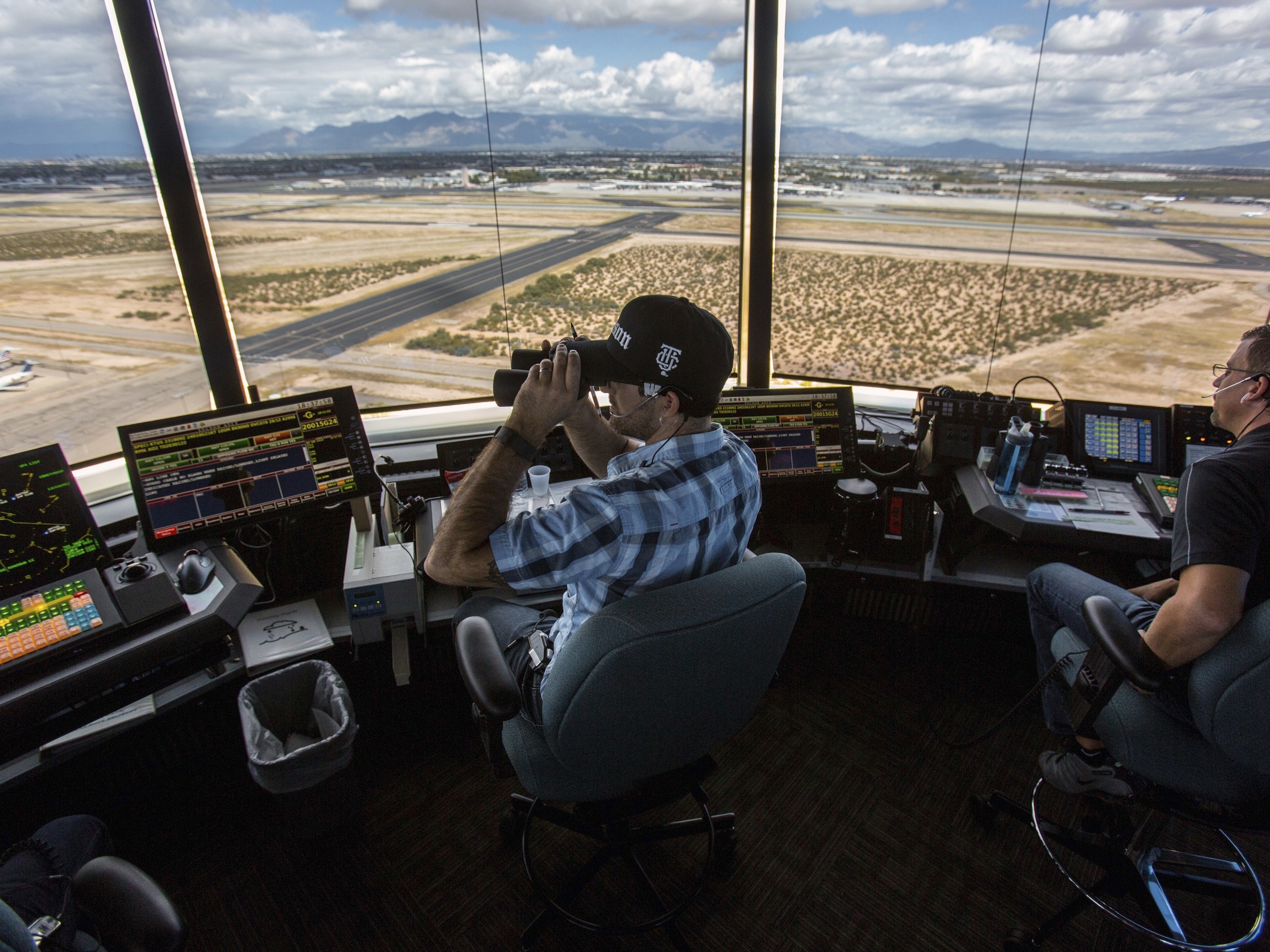 caption: Air traffic controllers watch for traffic from the control tower at the Tucson International Airport on Sept. 23, 2016 in Tucson, Ariz.