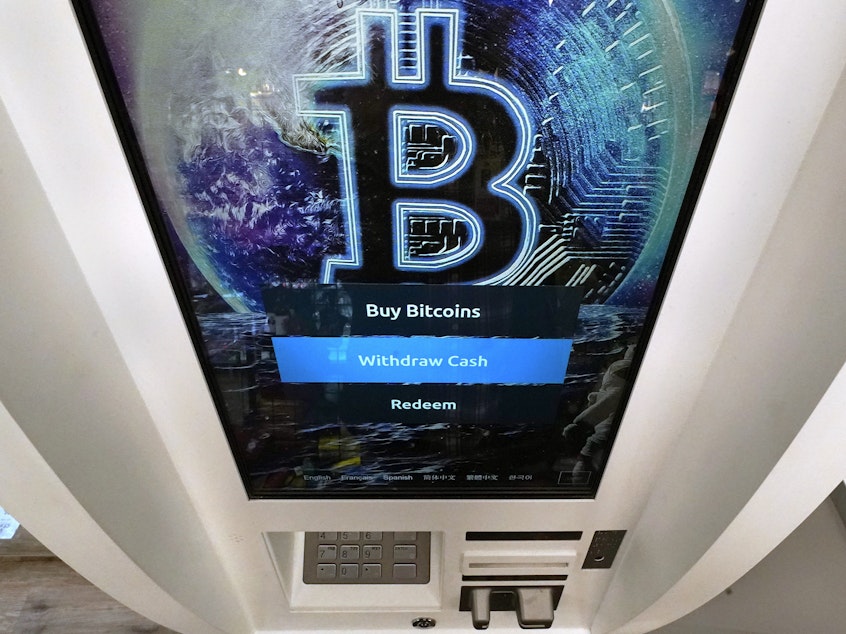 caption: Bitcoin logo appears on the display screen of a cryptocurrency ATM at the Smoker's Choice store in Salem, N.H. (AP Photo/Charles Krupa, File)