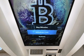 caption: Bitcoin logo appears on the display screen of a cryptocurrency ATM at the Smoker's Choice store in Salem, N.H. (AP Photo/Charles Krupa, File)