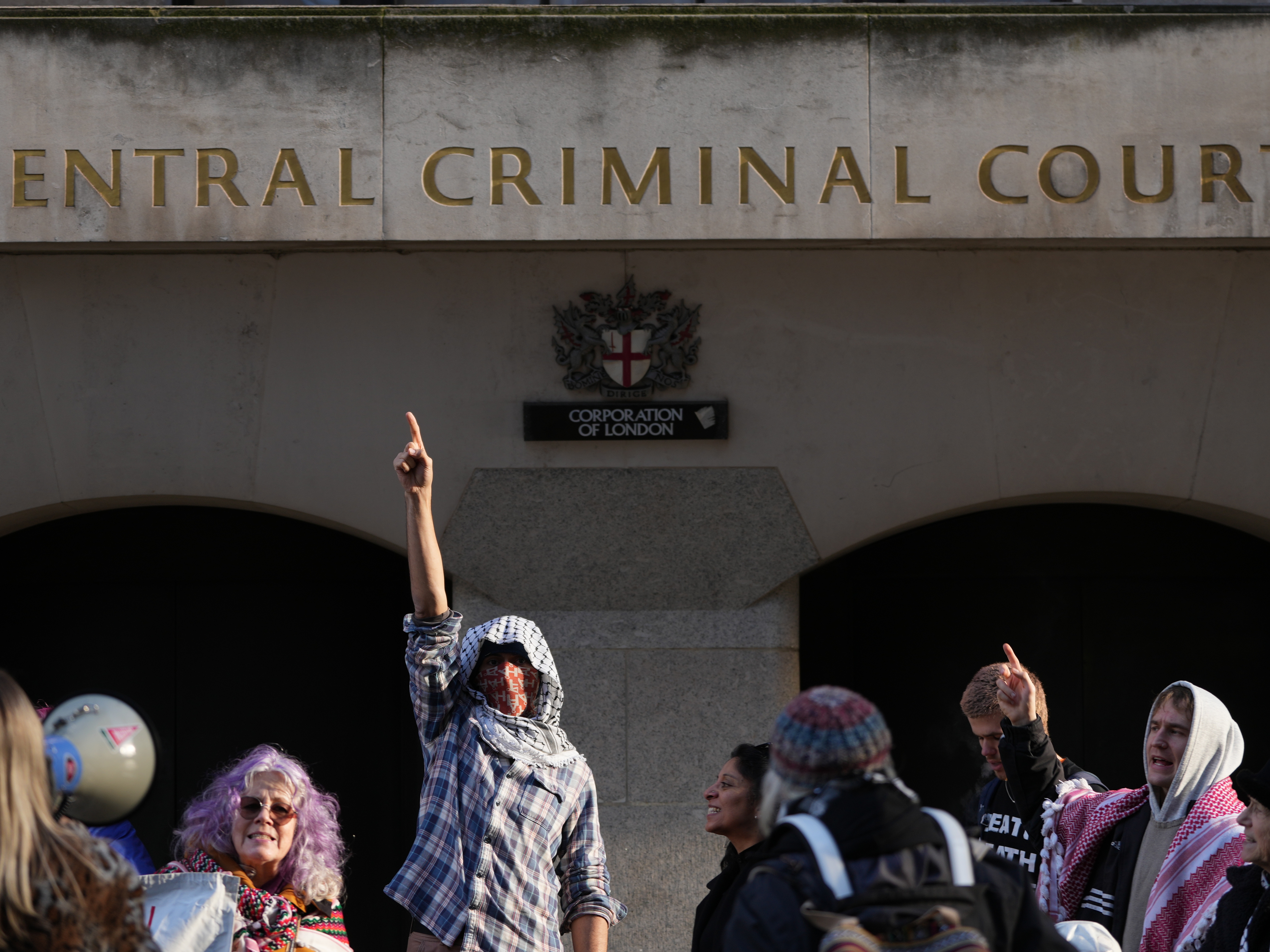 caption: Protesters demonstrate outside The Old Bailey court in London, where four Palestine Action activists are to appear in court charged over a break-in at RAF Brize Norton on June 20 in which aircraft were damaged with spraypaint, Friday, Jan. 16, 2026.