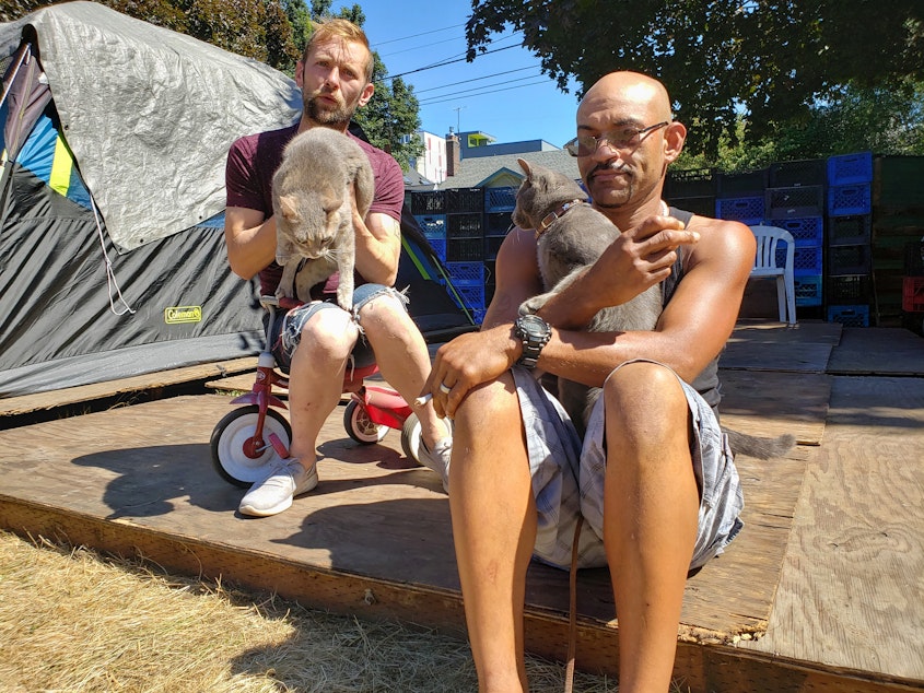 caption: Cassidy Katims (left) with his roommate's cat, Louie, and Mike Cleveland (right) with his cat, Mischief. Tent City 3 is home to many pets who will move to the new location in Tukwila.