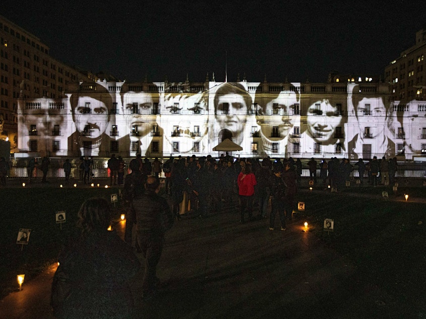 caption: A view of the images portraying victims of the Augusto Pinochet dictatorship projected onto the La Moneda Presidential Palace to mark the commemoration of the International Day of the Disappeared in Santiago, Chile, on Wednesday.